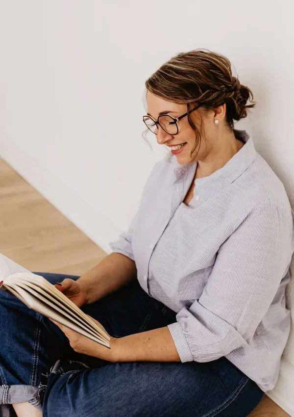 Swantje Neitzert im Schneidersitz mit Buch in der Hand von der Seite